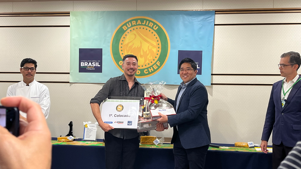 chef Ronaldo Ishizaka sendo congratulado por Jou Kawakubo da Kyodai Remittance após conquistar o 1º lugar no Burajiru Grand Chef 2024